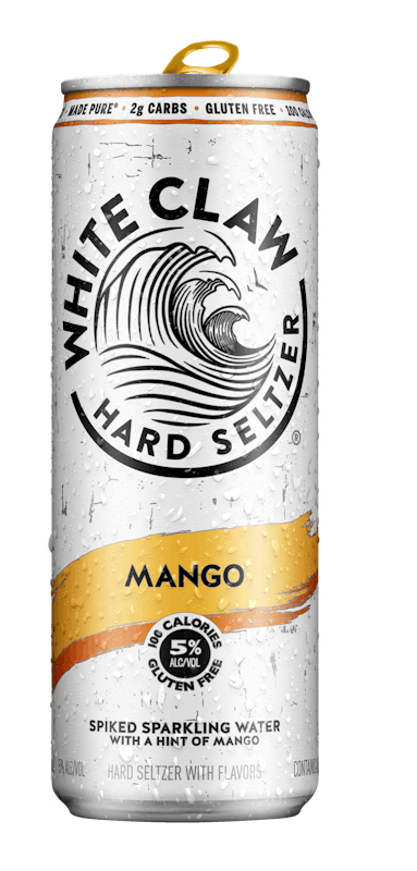 A can of White Claw® Hard Seltzer Mango sits on rocks in front of the sea.