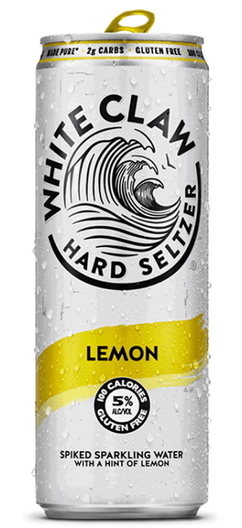 A can of White Claw® Hard Seltzer Lemon sits on rocks in front of the sea.