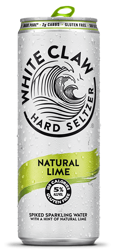 A can of White Claw® Hard Seltzer Natural Lime sits on rocks in front of the sea.