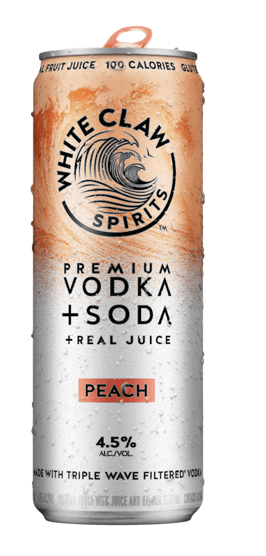 A can of White Claw™ Vodka + Soda Peach sits on rocks in front of the sea.