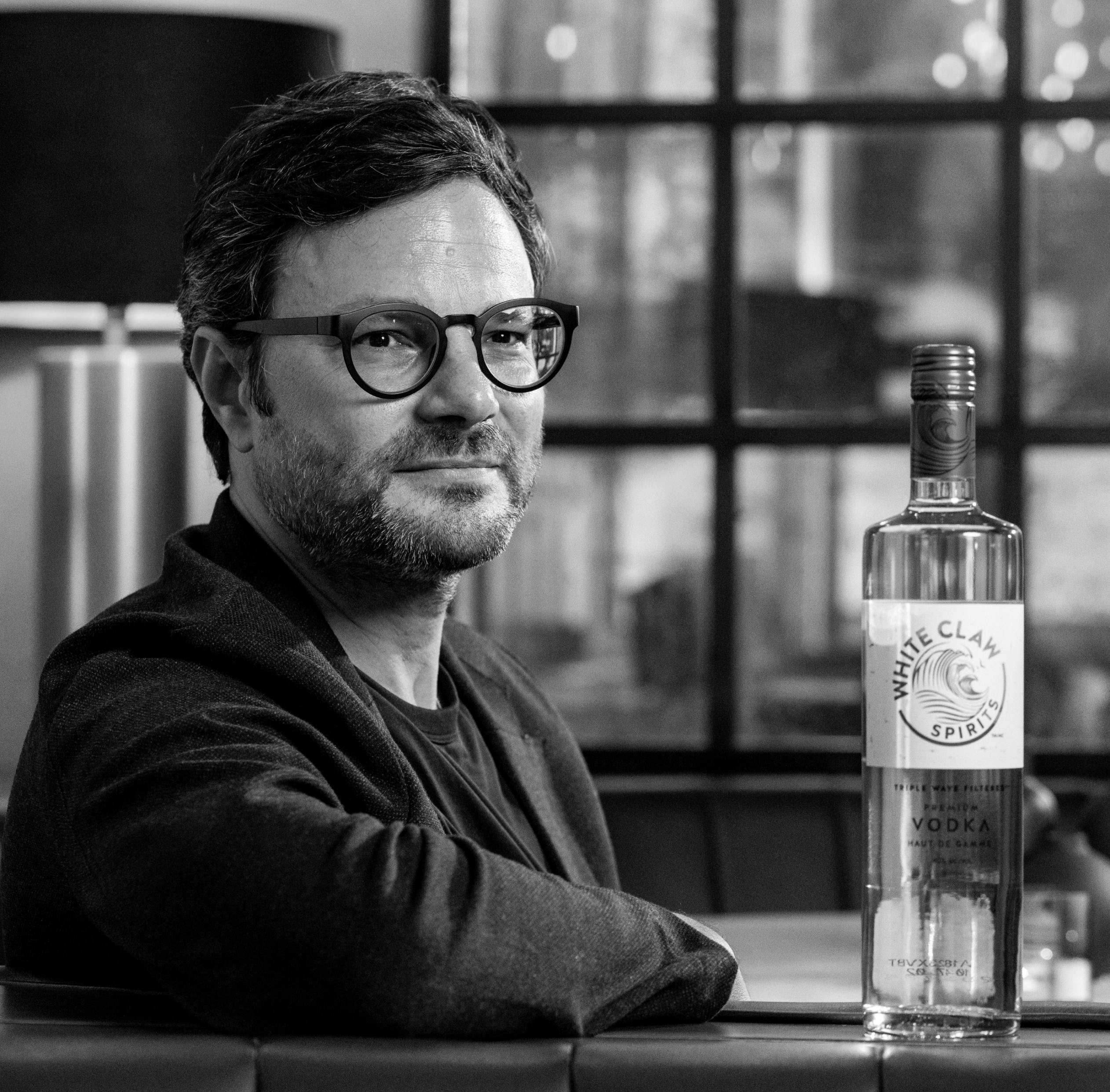 El maestro mezclador de vodka Andres Faustinelli posa junto a una botella de vodka White Claw™ Premium.		