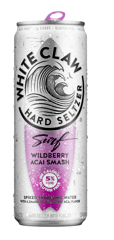 A can of White Claw® Surf Wildberry Açai sits on rocks in front of the sea.