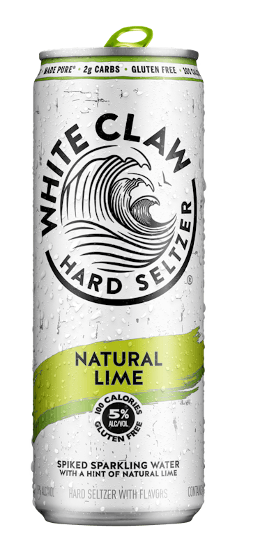 A can of White Claw® Hard Seltzer Natural Lime sits on rocks in front of the sea.