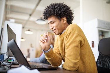 Man at work wearing brown sweater investing his emergency fund