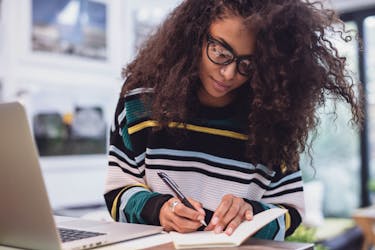 Woman is creating an online course by writing down a course outline