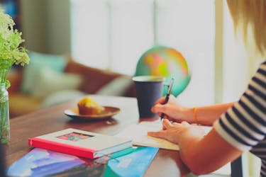 Woman writing in the notebook to reflect on "how to find yourself"