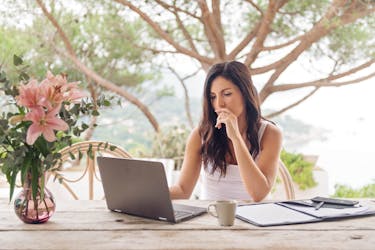 Woman uses laptop to access income protection insurance to protect her income