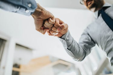 Fist bump by two man who just finished a financial education class