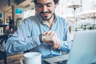 Man looking at his watch, checking real estate investment properties.