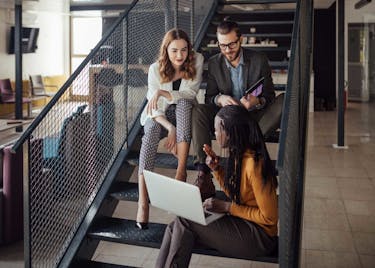 Characteristics of great leaders discovered by coworkers in the office, on steps.