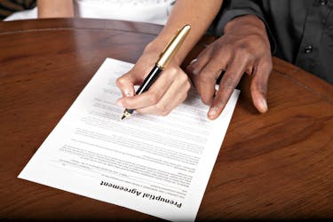 A couple signing a prenup before marriage