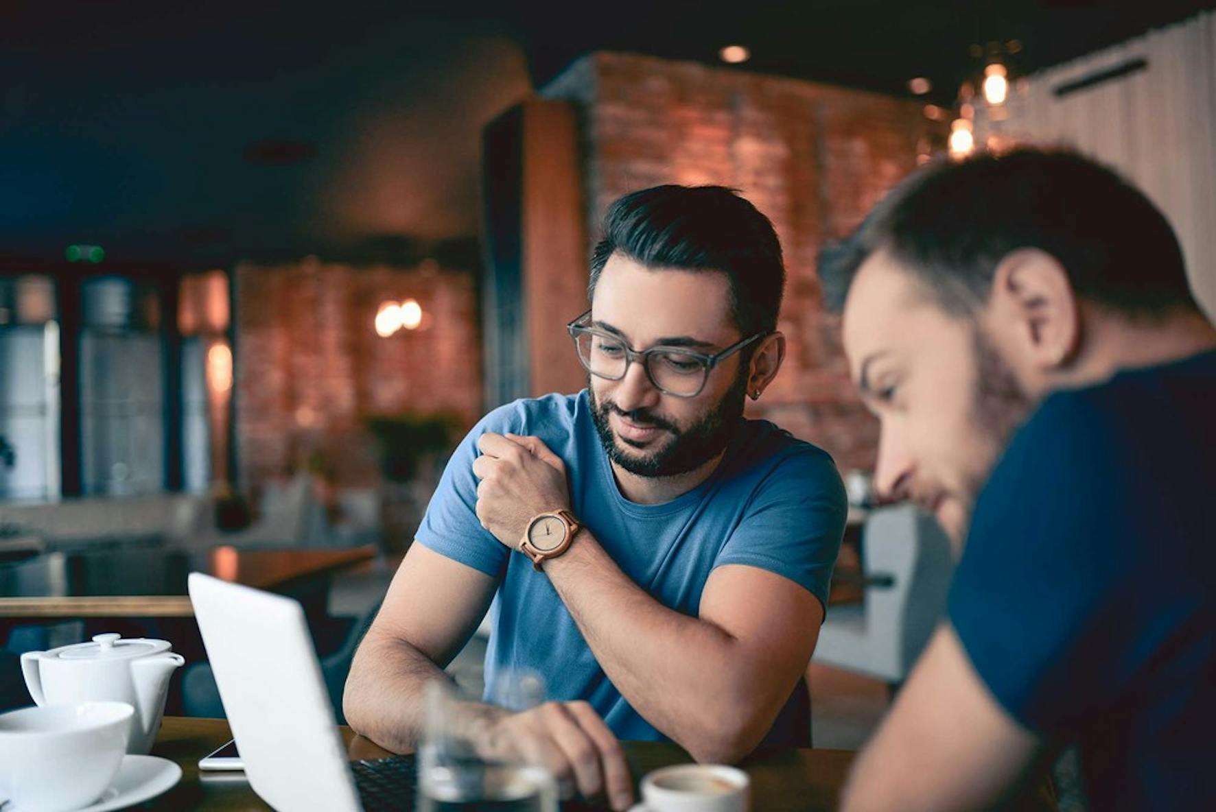 2 men reviewing the process of managing a full-time job and side business on a computer