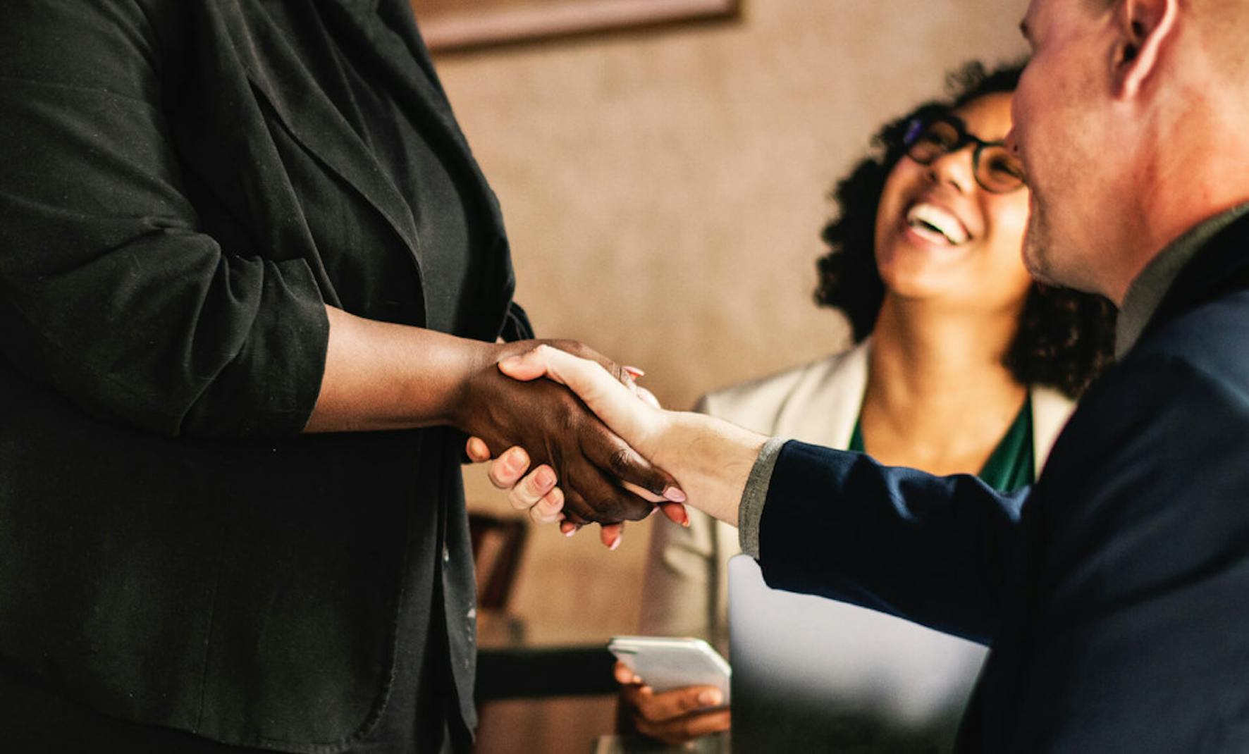 Man shaking a woman's hand at a business meeting