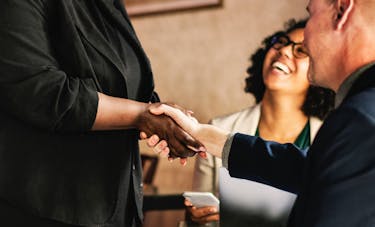 Man shaking a woman's hand at a business meeting