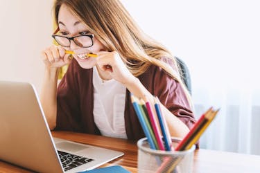 Small business owner stressing about filing small business taxes for the first time by biting a pencil