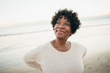 Woman on the beach thinking about how to overcome adversity