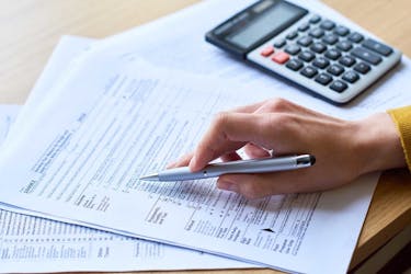 Determining how much small business tax is owed using IRS forms and a calculator