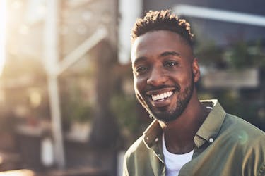 Man smiling because he kickstarted retirement in his 20s