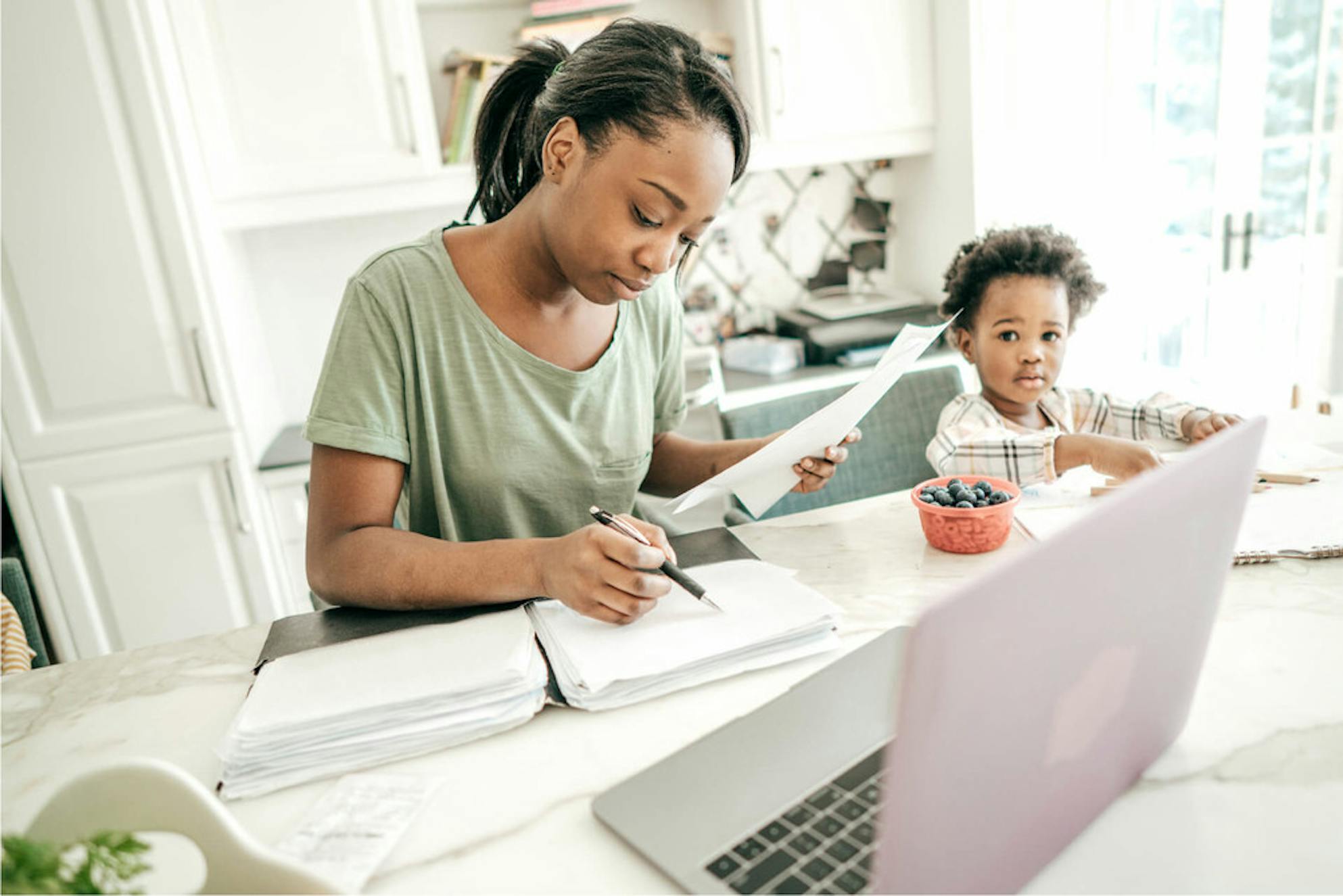 Woman working on her taxes with her son from her home