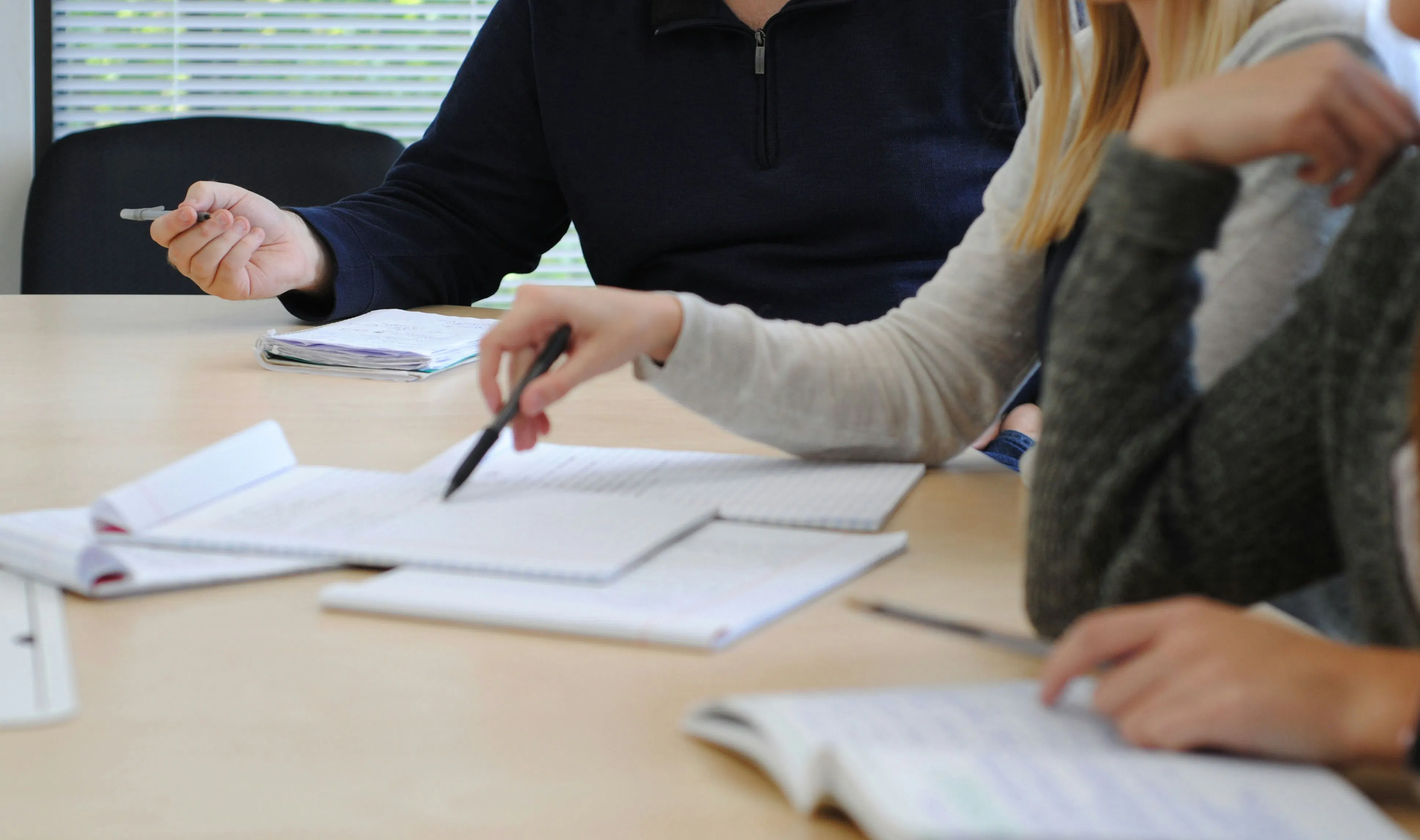 einige Personen, die an einem Tisch arbeiten