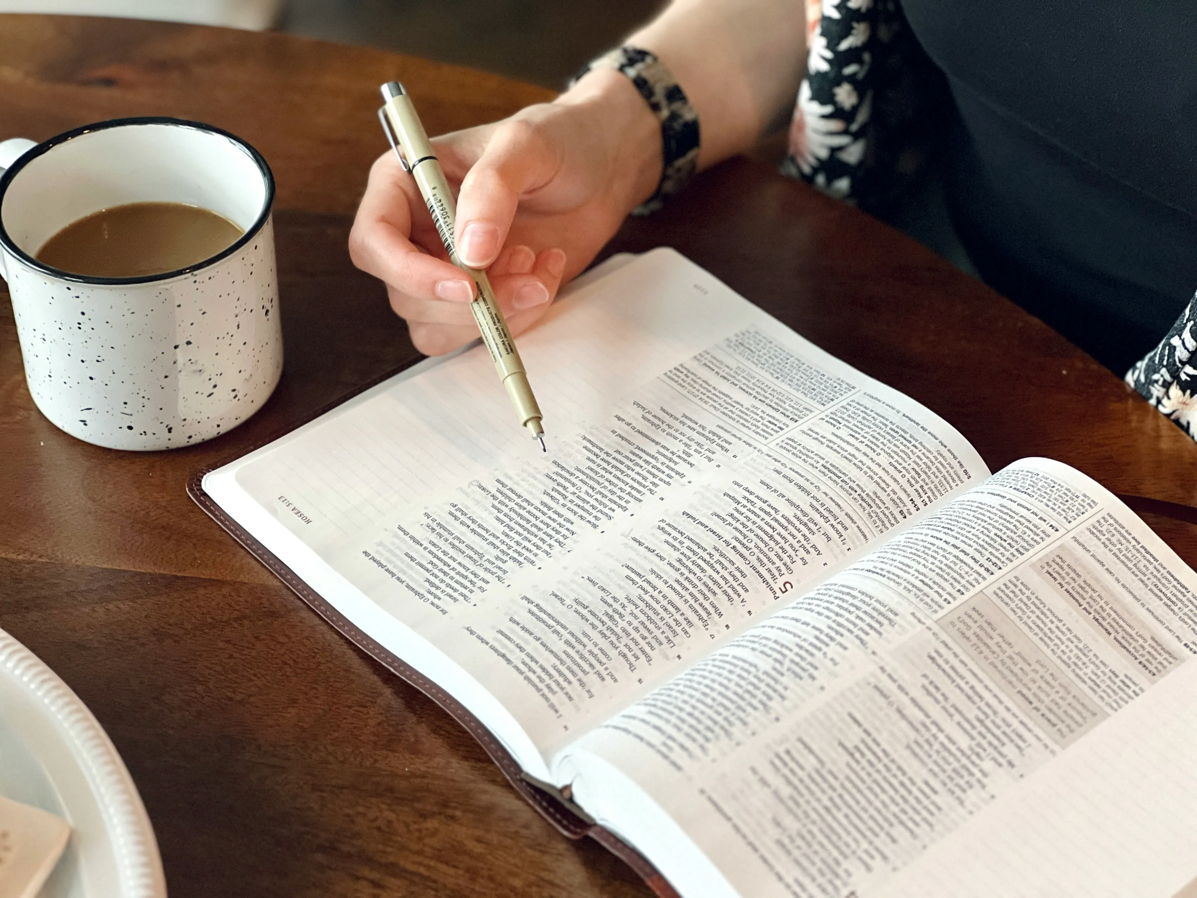eine Person, die an einem Tisch mit einem Buch und einem Stift sitzt