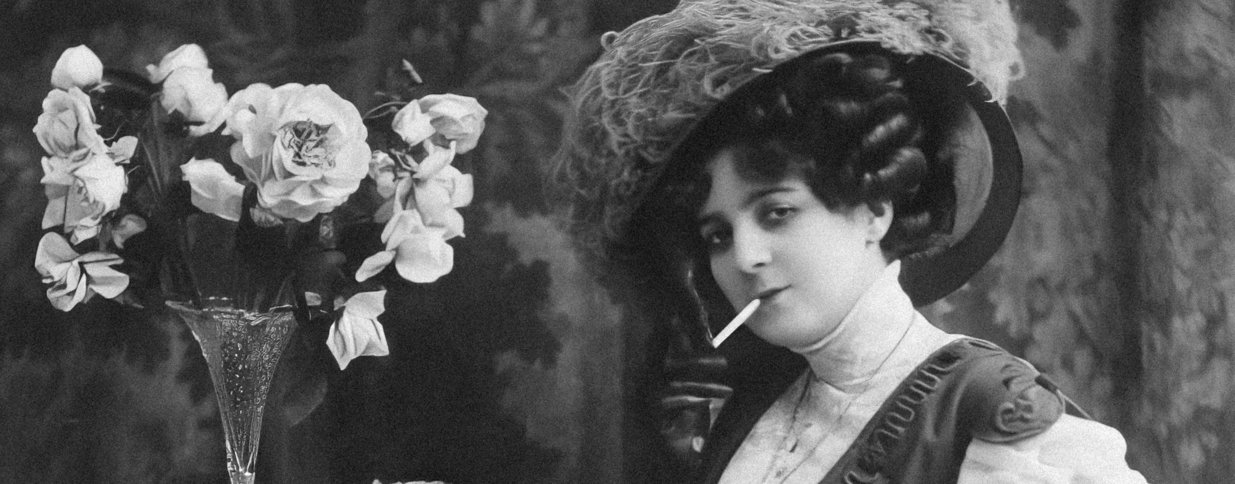 امرأة جالسة على طاولة مع مزهرية من الزهور