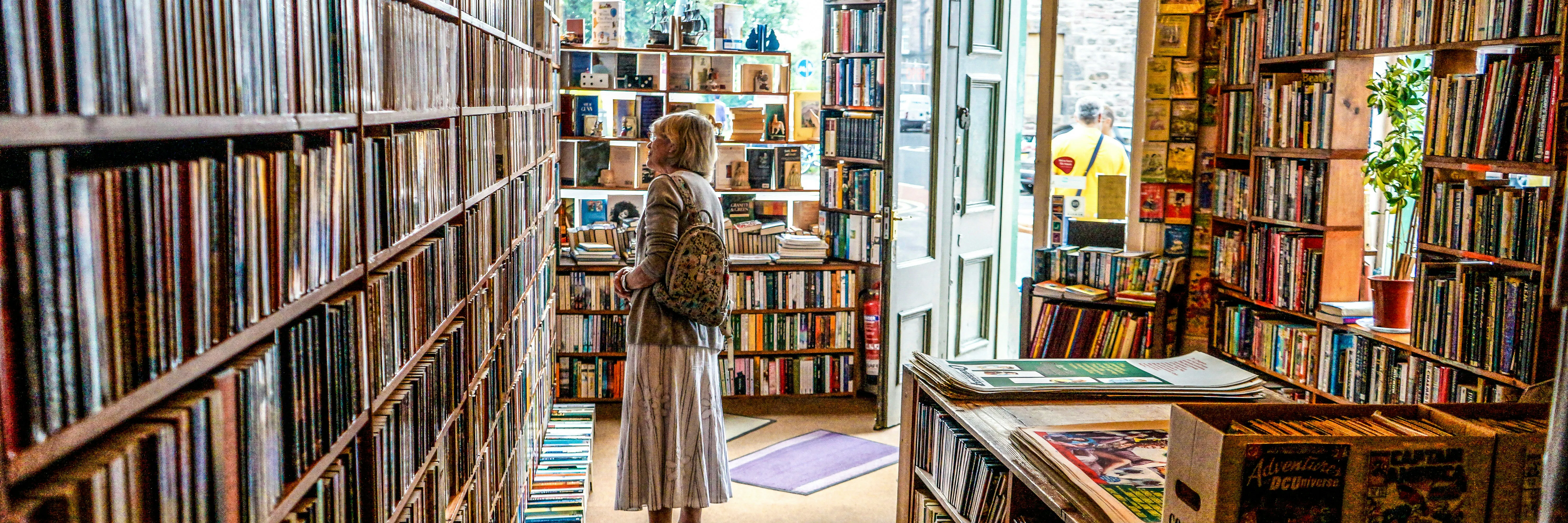 donna dentro una biblioteca che guarda i libri