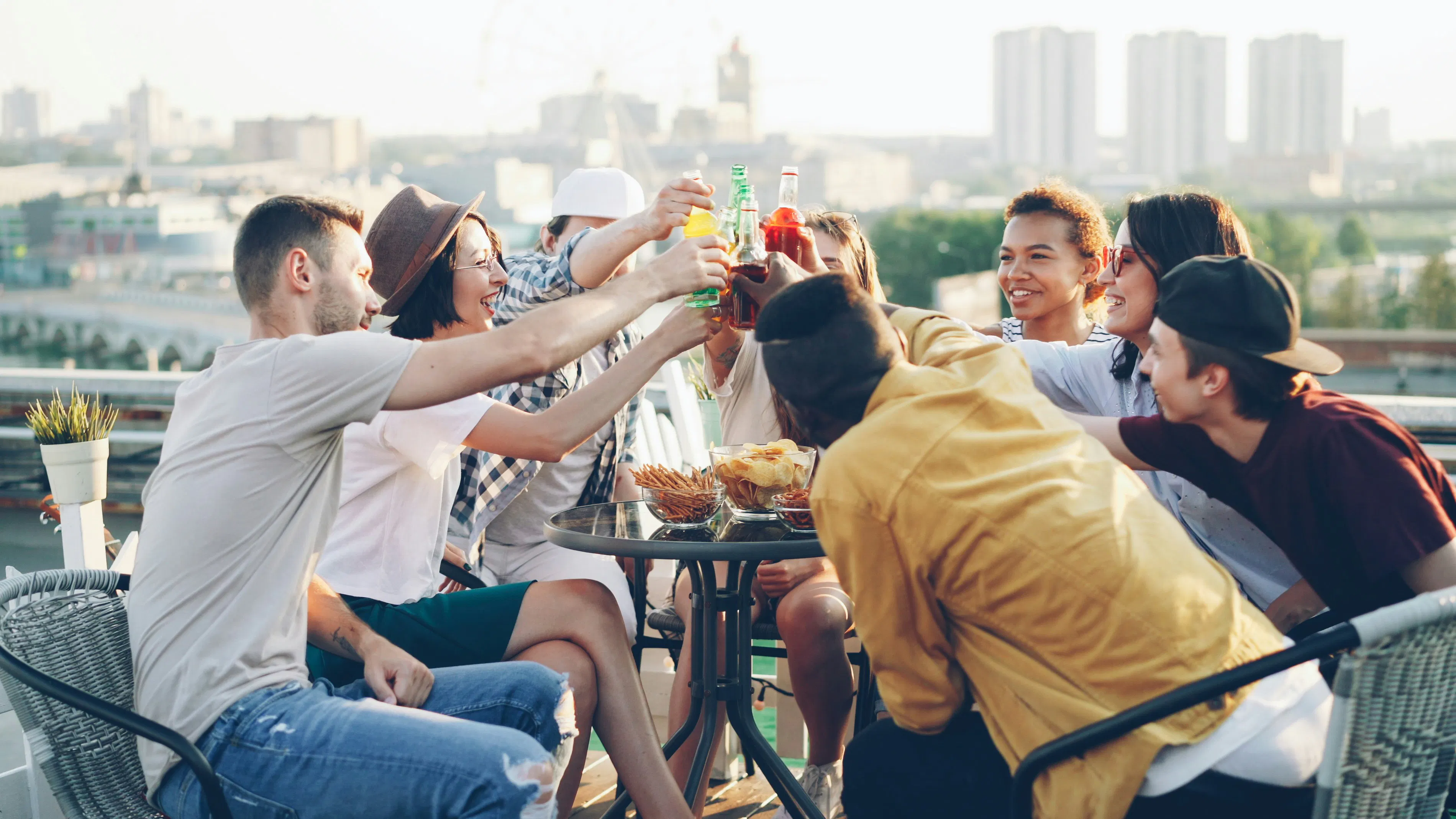 Amici che brindano con drink a una festa sul tetto.