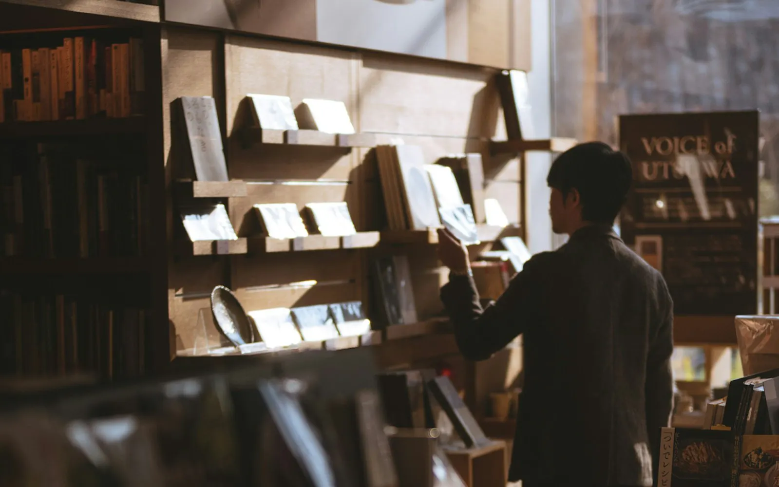 رجل واقف داخل مكتبة يبحث عن كتب