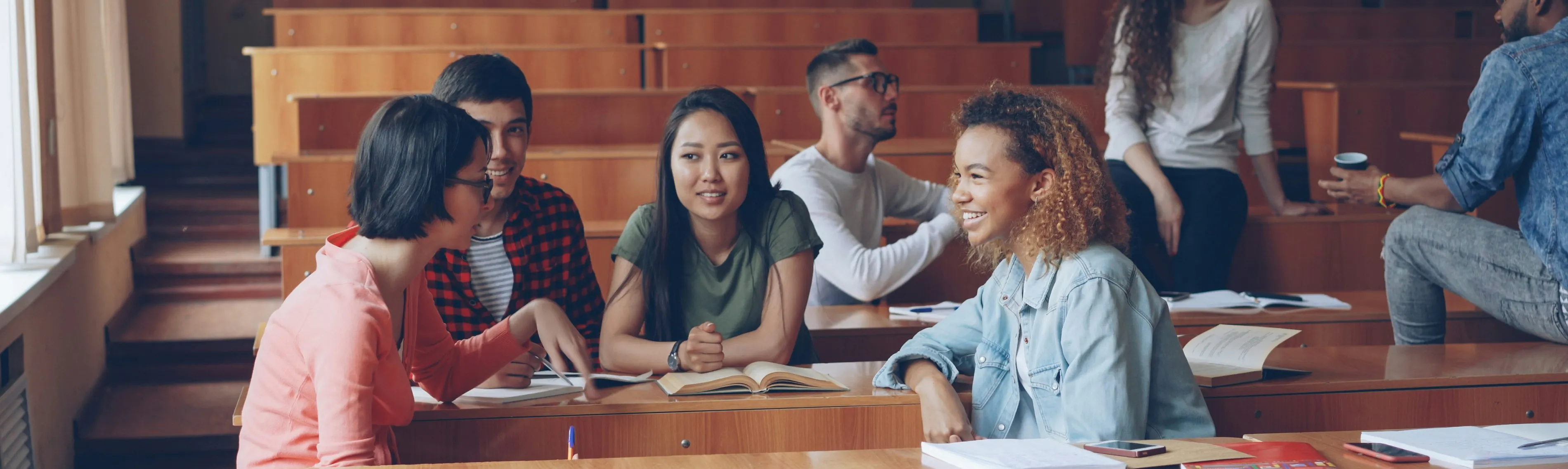 Studenti che parlano e studiano in un'aula.