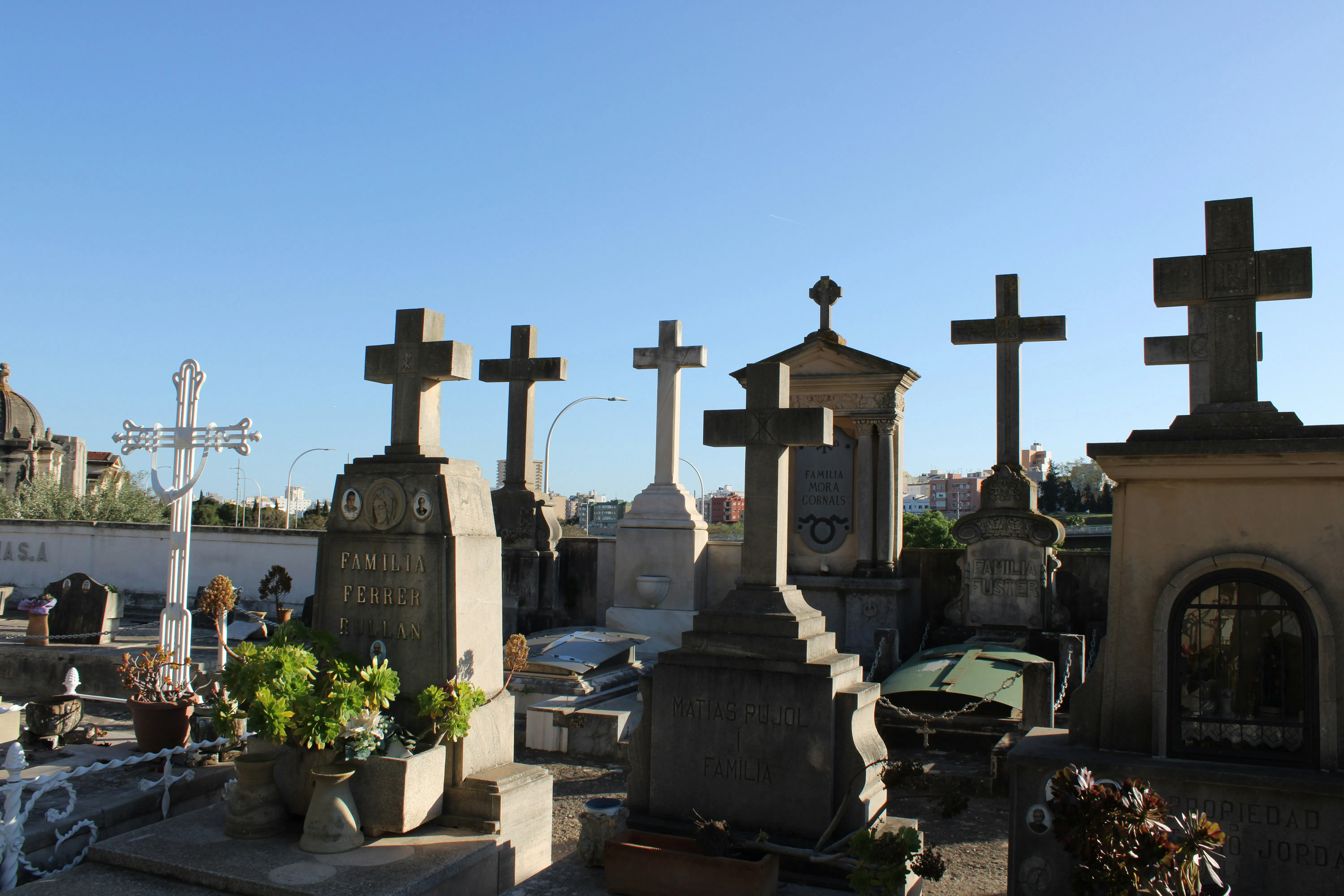Un cimitero mostra molte croci e lapidi.