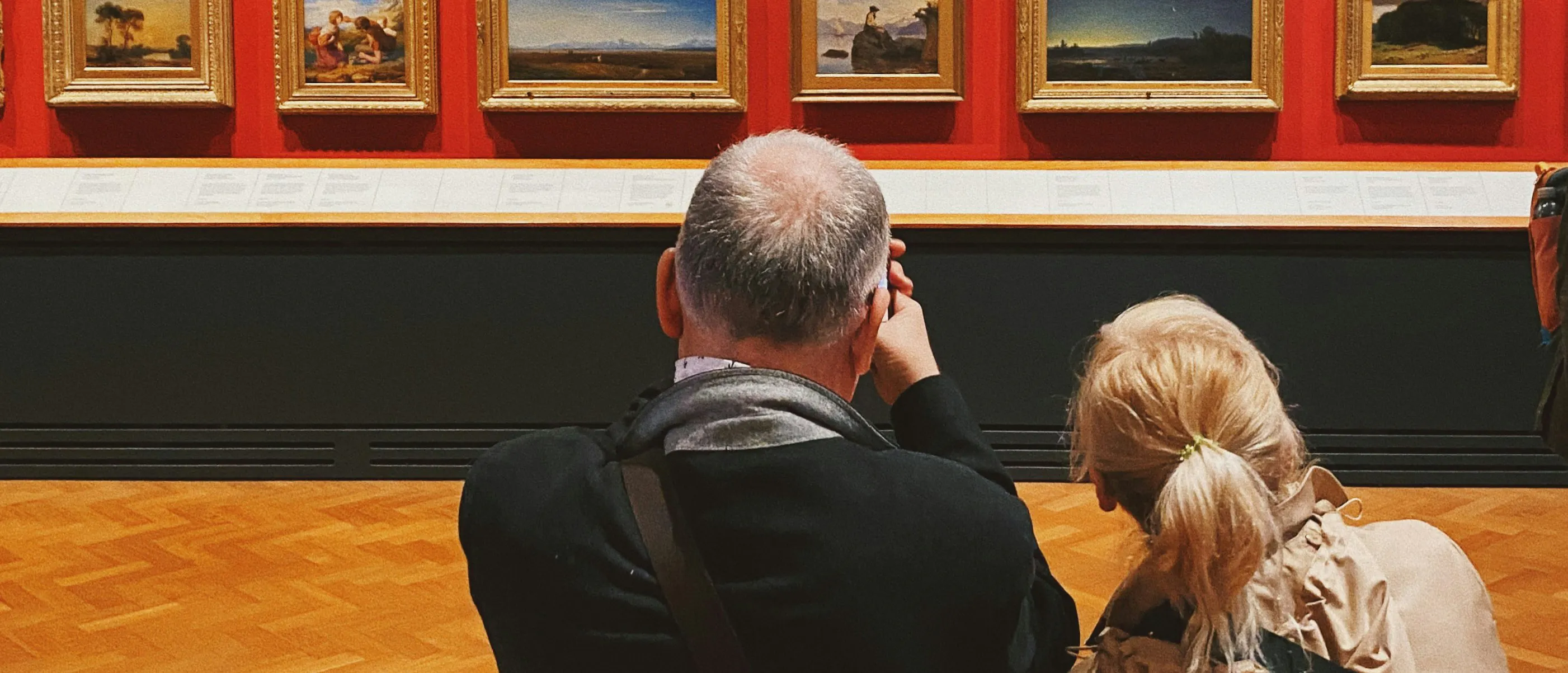 美術館で絵画を鑑賞している人々。