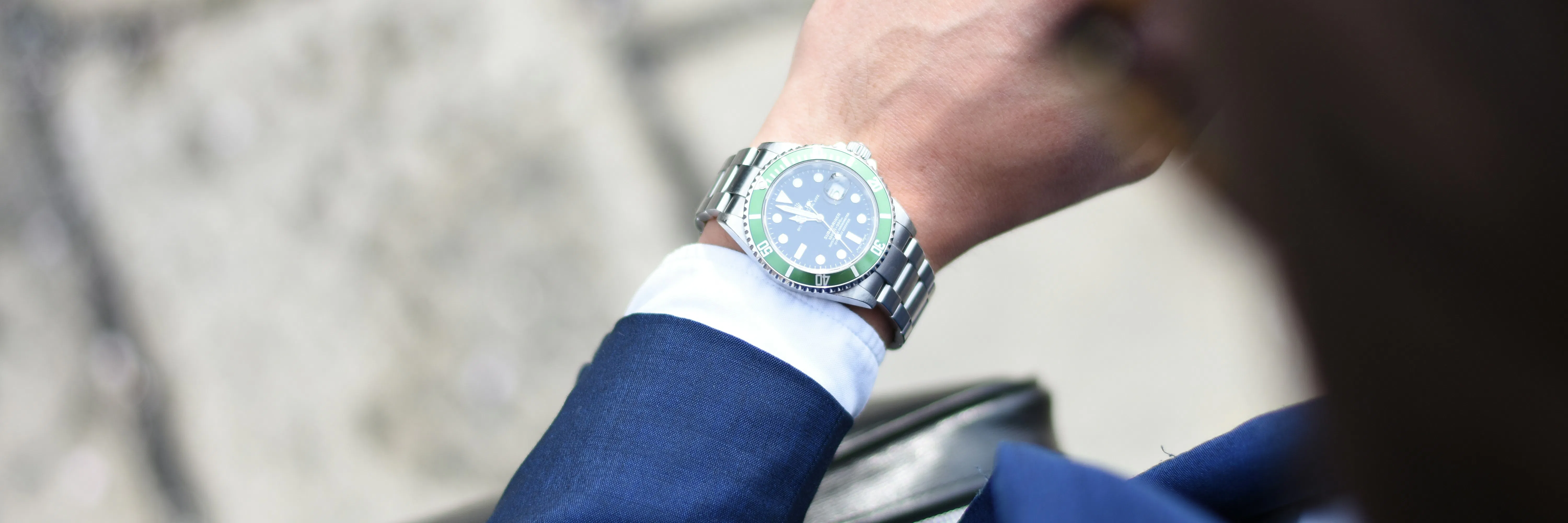 persona che guarda un orologio analogico color argento