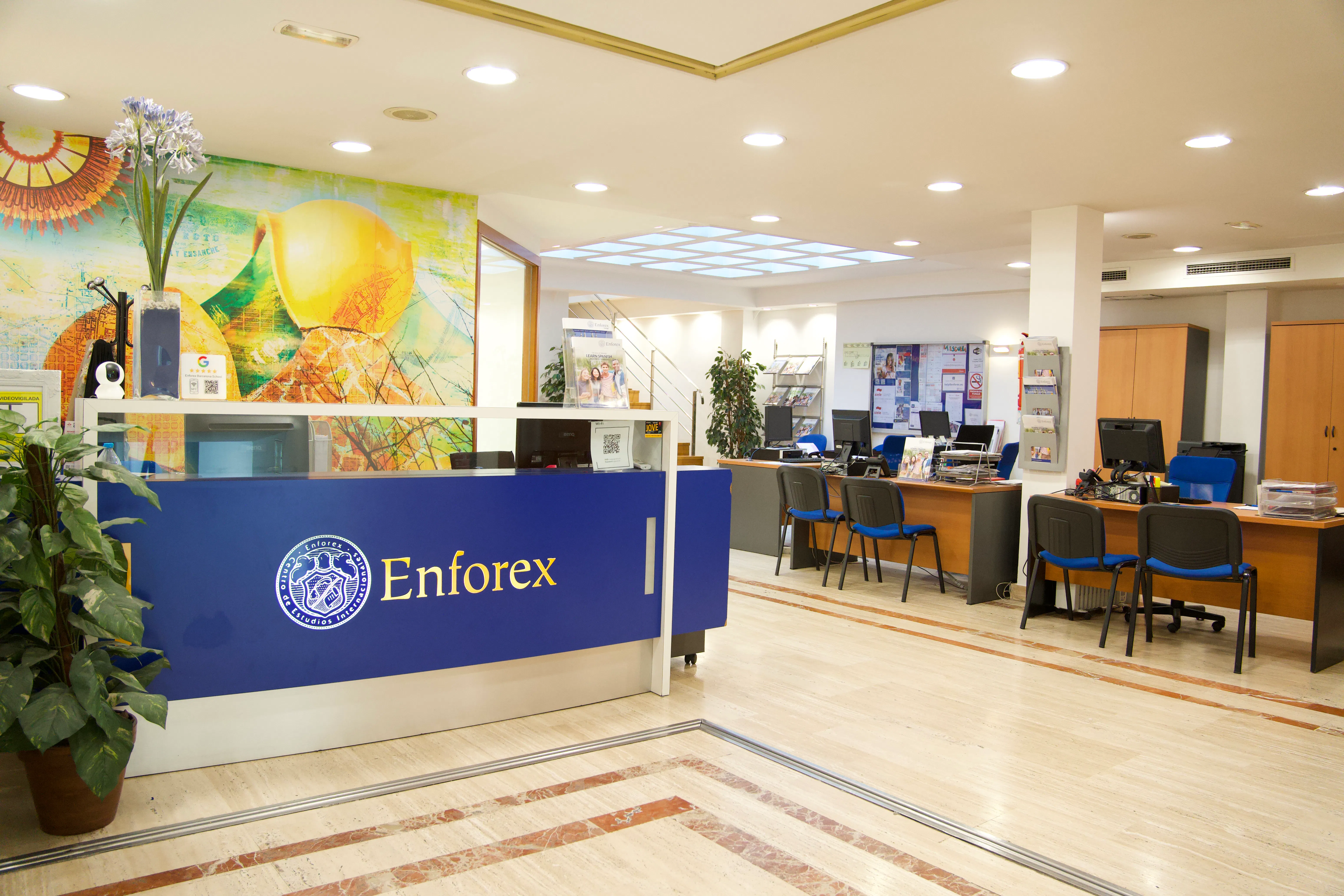Área de recepção de uma escola da Enforex, com balcão de informações e ambiente acolhedor de atendimento ao estudante