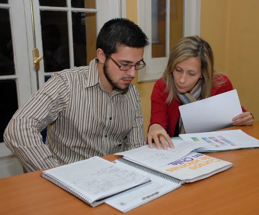 Studenti che rivedono materiali e lavorano insieme durante una lezione di spagnolo