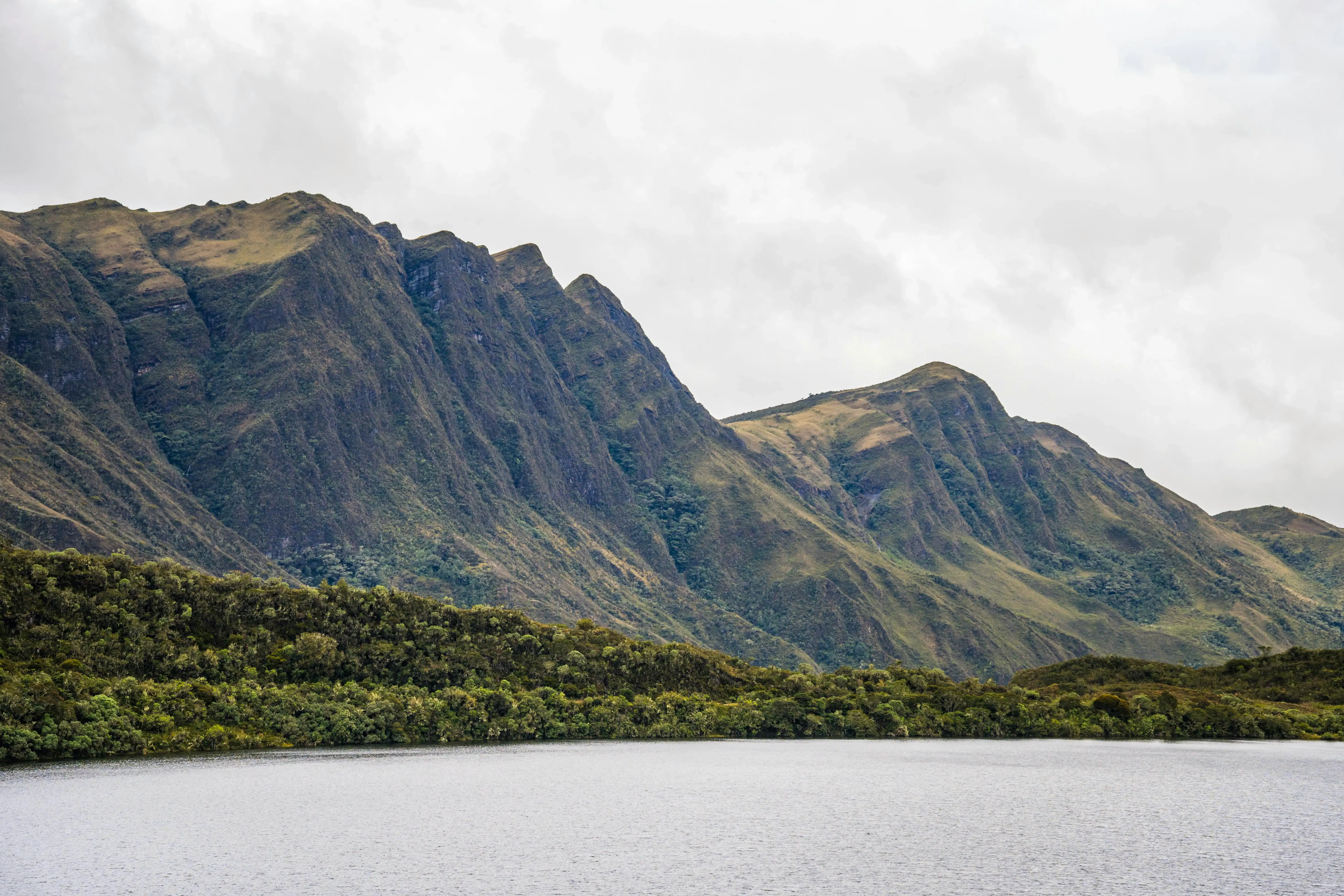 Paesaggio naturale in Colombia con montagne verdi e un lago sotto un cielo nuvoloso