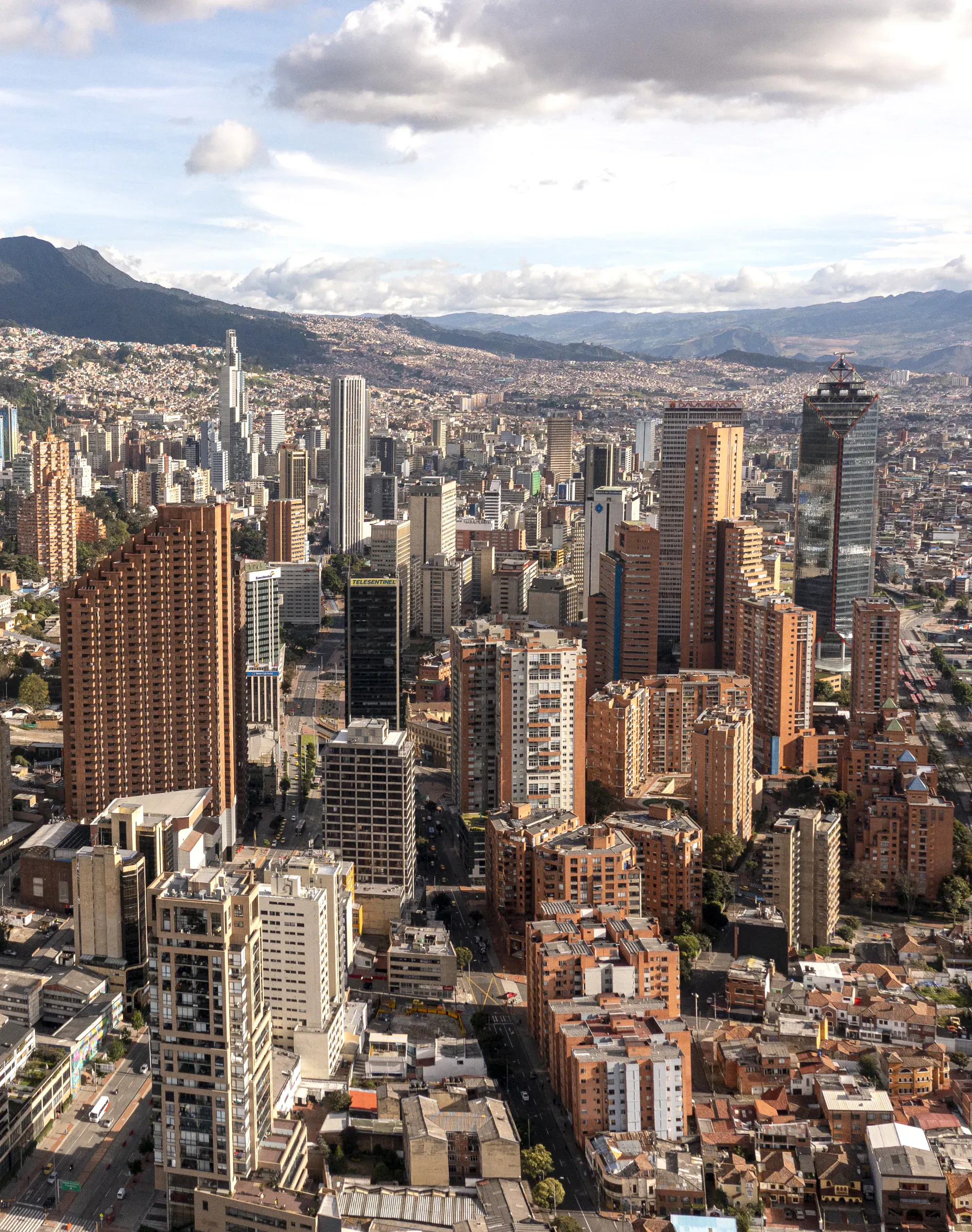 Bogotá con grattacieli, montagne e una vasta area urbana sotto un cielo nuvoloso