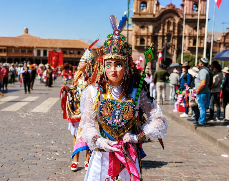 Persona in costume tradizionale peruviano durante una celebrazione culturale in una piazza storica