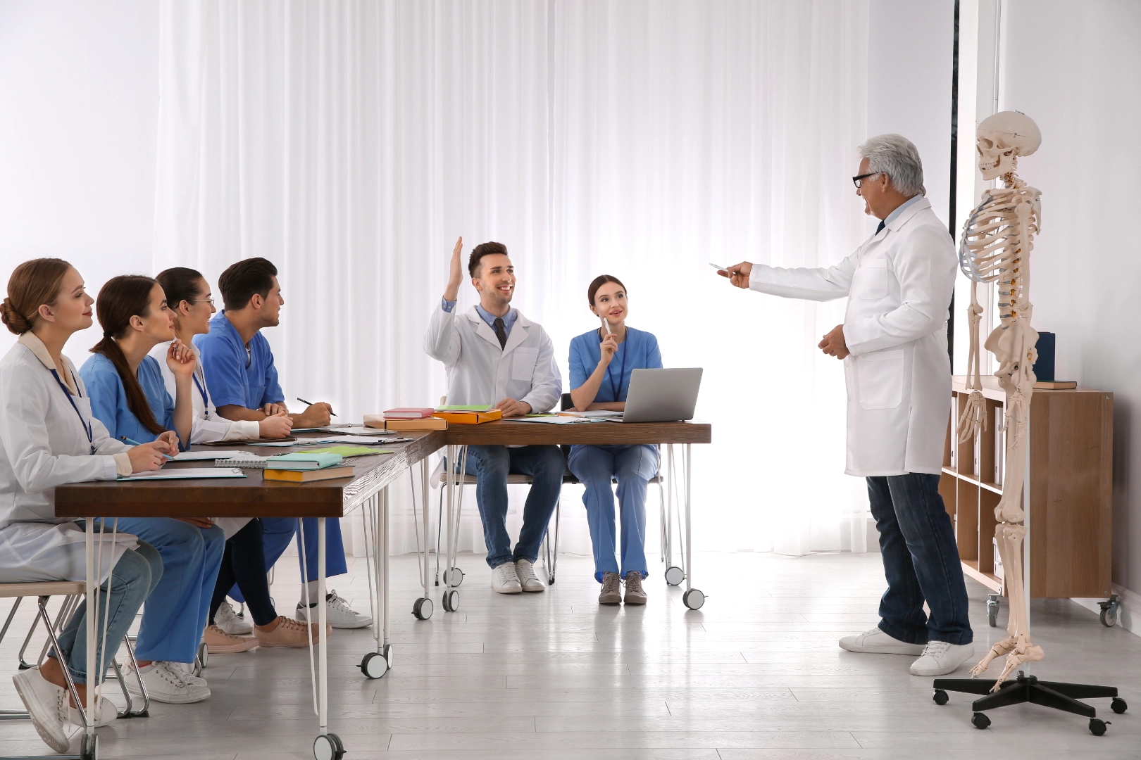 Medical professor teaching anatomy to students in a modern classroom with a skeleton model