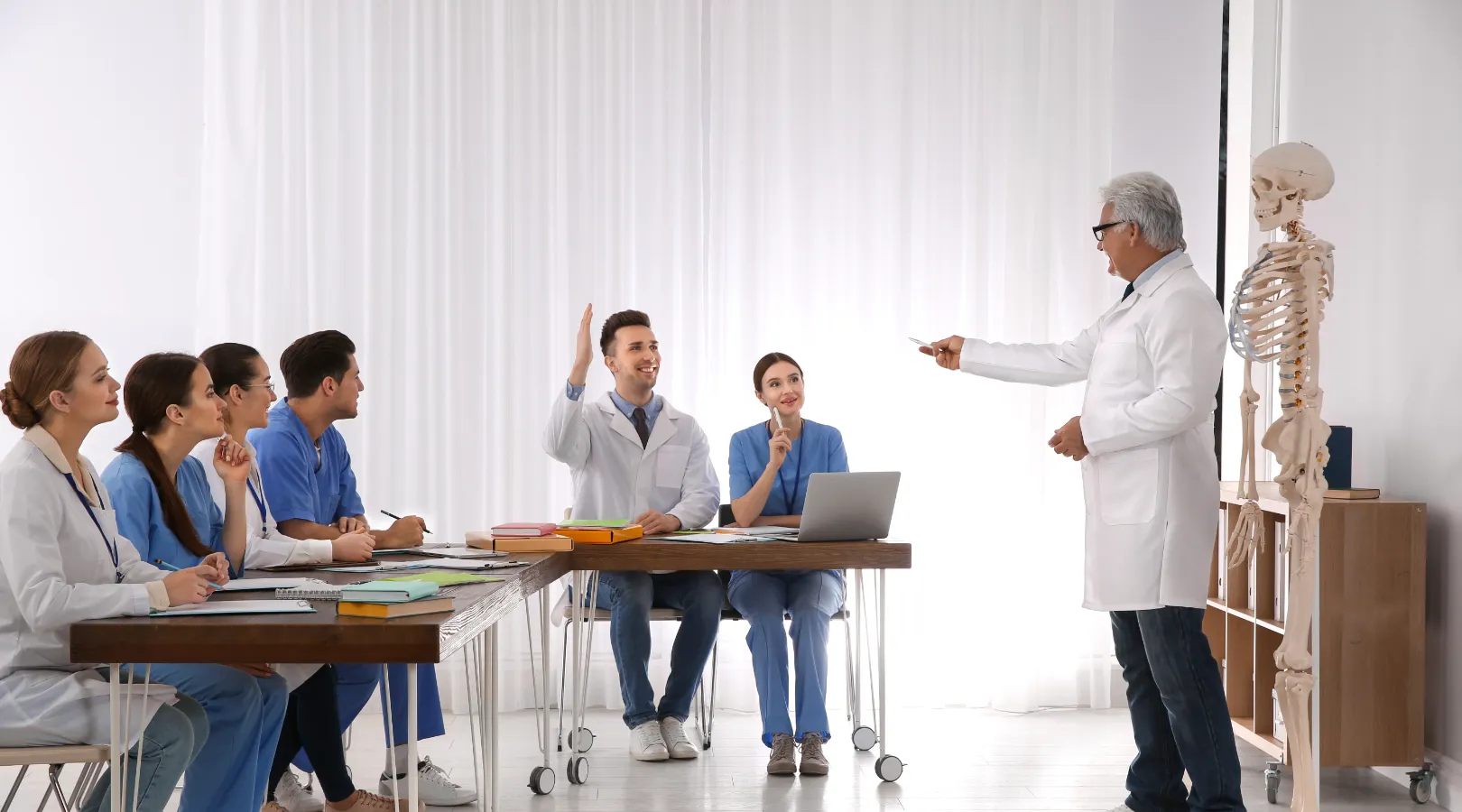 Medical professor teaching anatomy to students in a modern classroom with a skeleton model