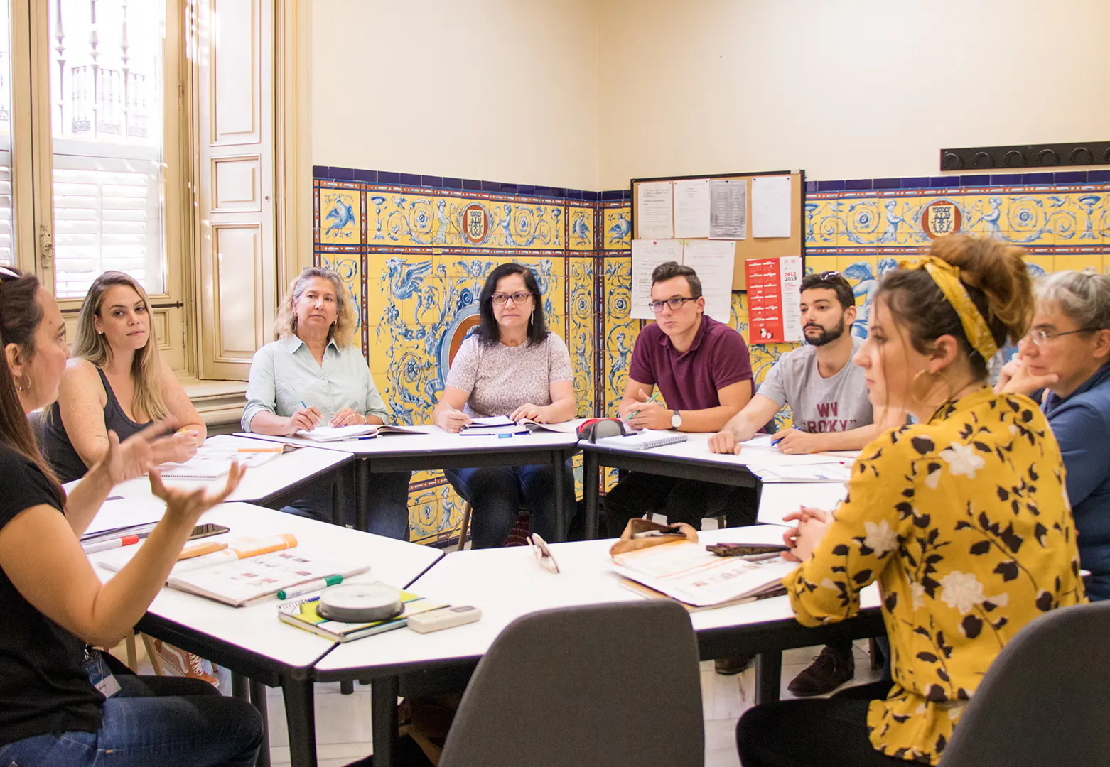 Estudantes internacionais aprendendo espanhol juntos na atmosfera vibrante e acolhedora de Sevilha