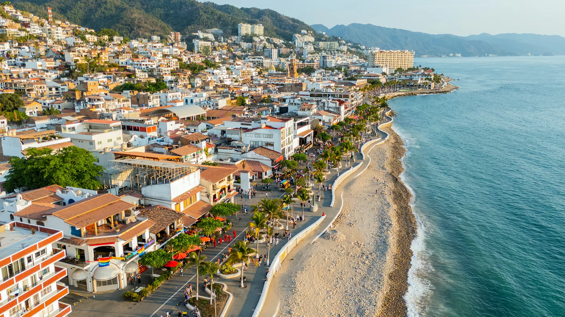 Vista aerea di una città costiera con spiaggia, lungomare e edifici vicino all'oceano