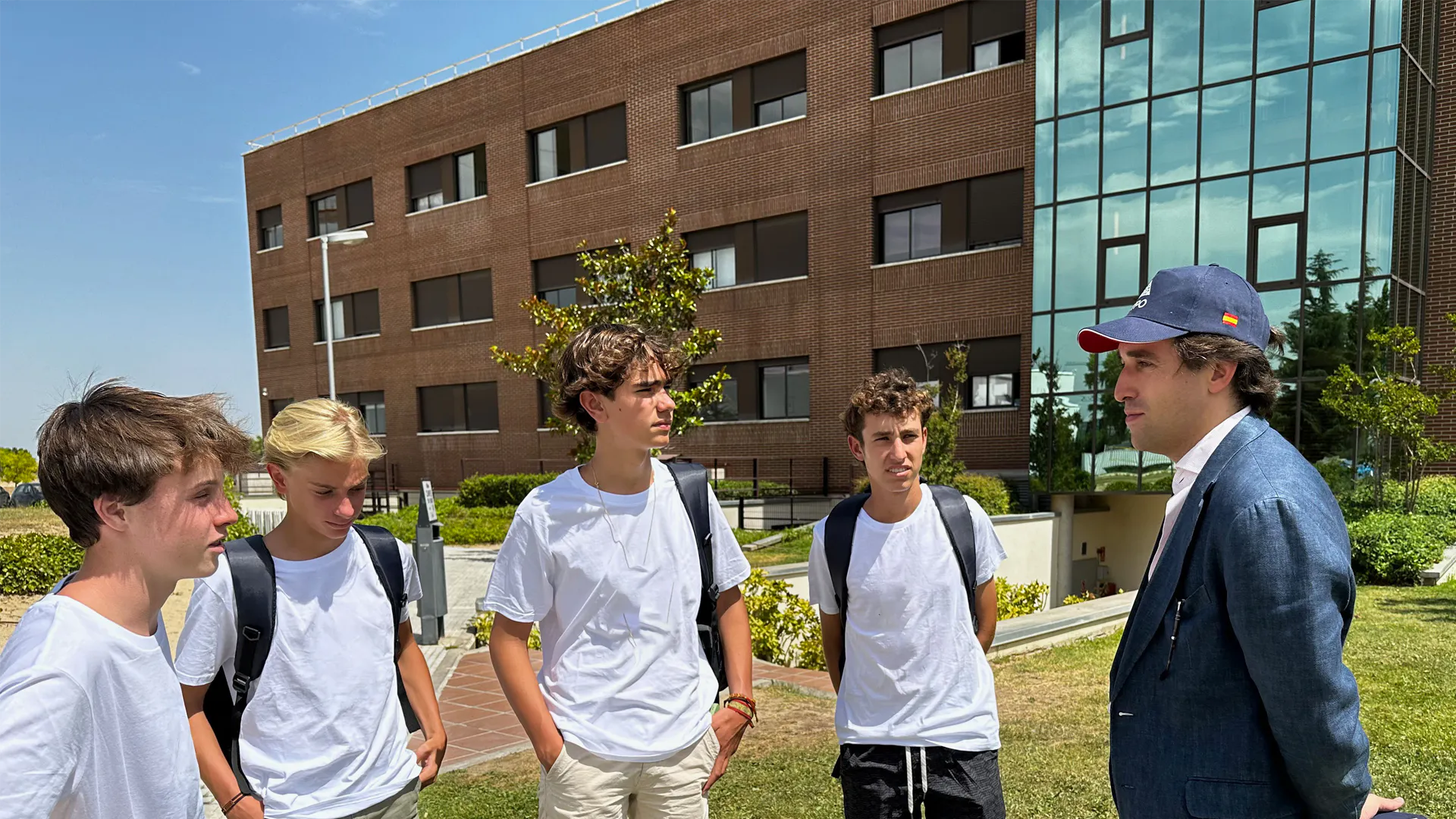 Gruppenfoto des Leadership-Programms mit vier Schülern und Fernando Alonso vor dem Campus der Universidad Francisco de Vitoria.