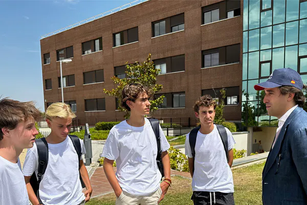 Grupo do programa de liderança com quatro estudantes e Fernando Alonso, em frente ao campus da Universidad Francisco de Vitoria.