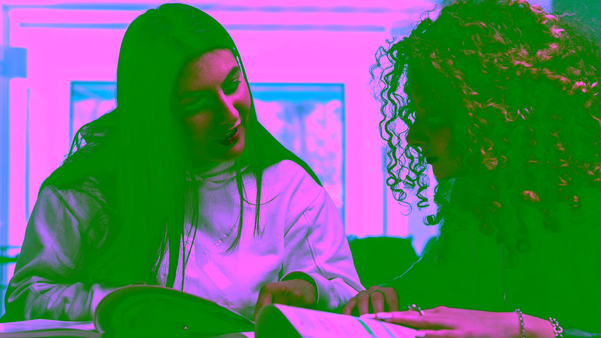 Duas estudantes em uma aula individual de espanhol com livros.