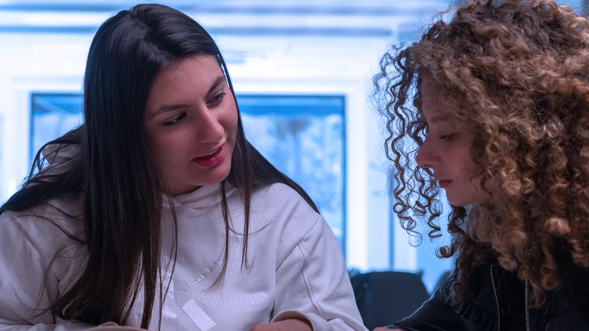 Duas estudantes em uma aula individual de espanhol com livros.