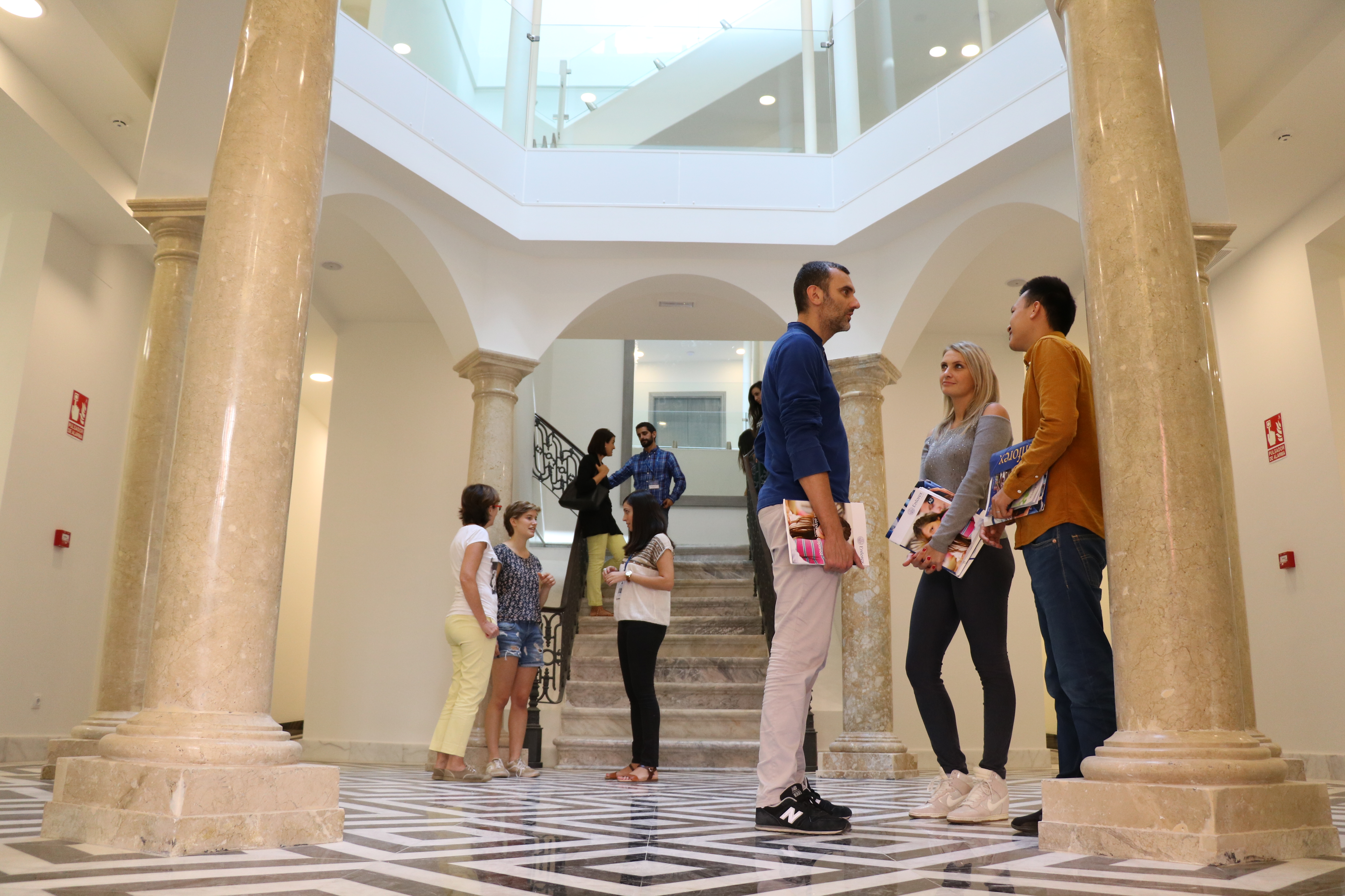 Estudantes interagindo na área de entrada de uma escola Enforex, criando uma atmosfera de campus acolhedora e social