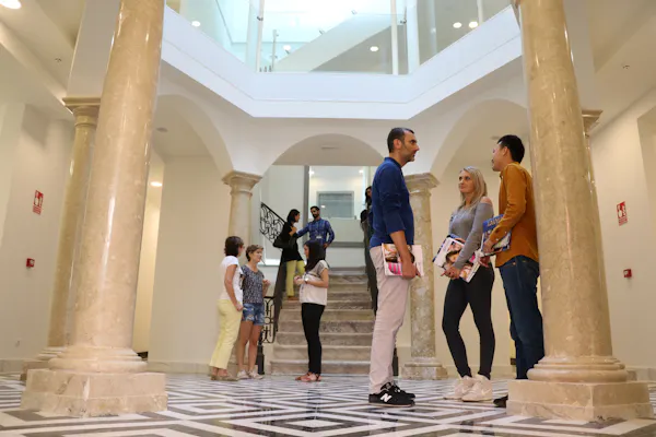 Estudantes interagindo na área de entrada de uma escola Enforex, criando uma atmosfera de campus acolhedora e social