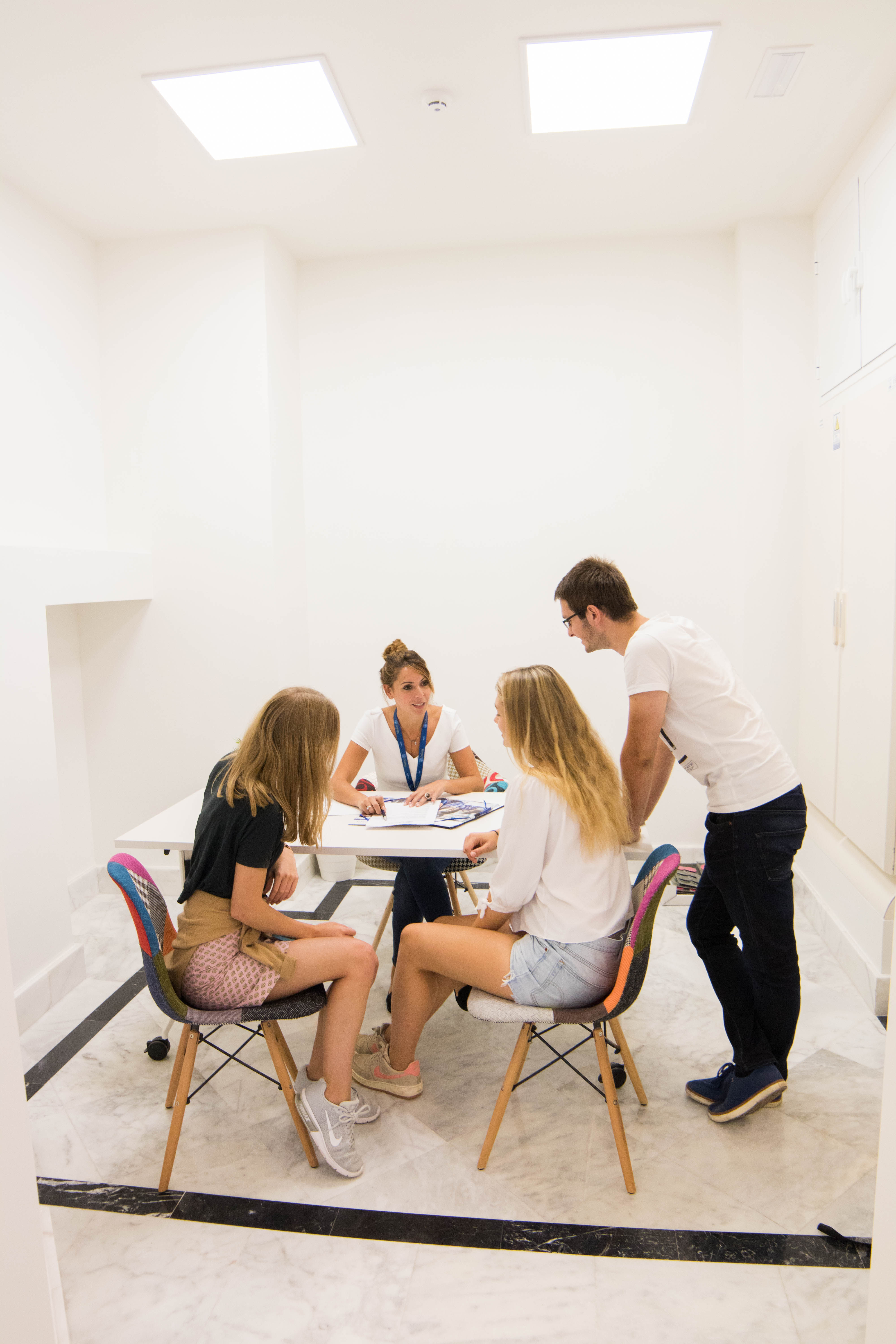 Três estudantes recebendo assistência e orientação para se matricular em uma escola Enforex, representando o suporte à matrícula dos estudantes e os serviços de orientação de admissões