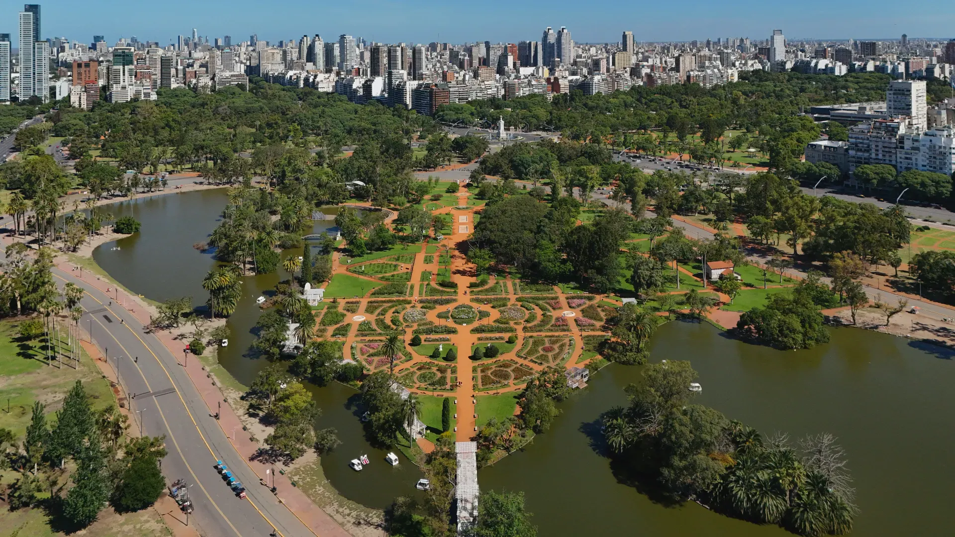 Parco urbano con giardini geometrici, laghi ed edifici della città sullo sfondo